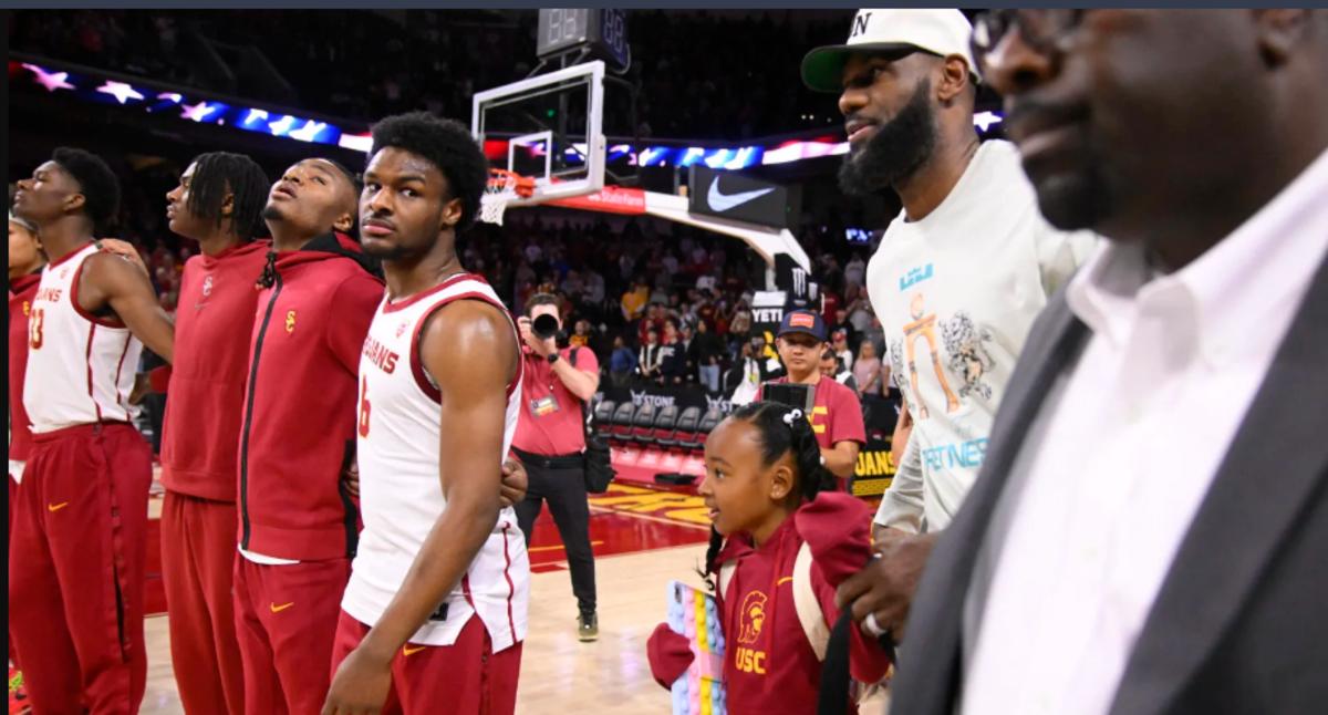 Bronny James (fourth from left) watches his father LeBron arrive prior to his collegiate debut